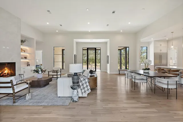 a living room with fireplace furniture and a large window