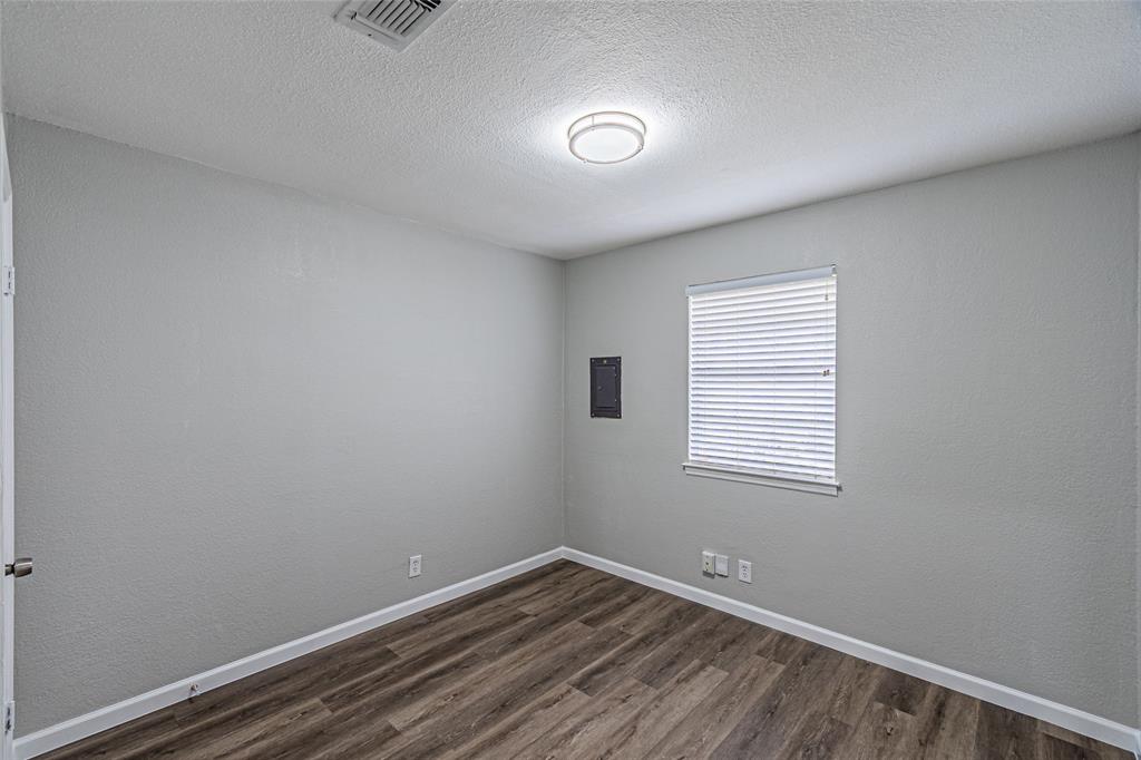 1205 Navaho Street Arlington, TX 76012 - Photo 13 of 18 a view of an empty room with wooden floor and a window