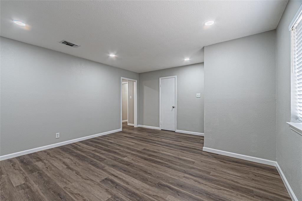 1205 Navaho Street Arlington, TX 76012 - Photo 8 of 18 an empty room with wooden floor and windows