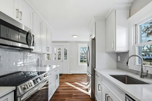 a kitchen with stainless steel appliances granite countertop a sink stove and cabinets