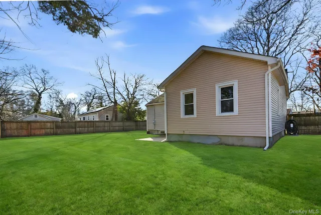 a house that is sitting in the grass with tress in the background