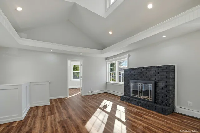 an empty room with windows and a fireplace