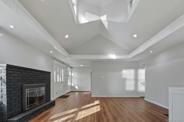 an empty room with windows and fireplace