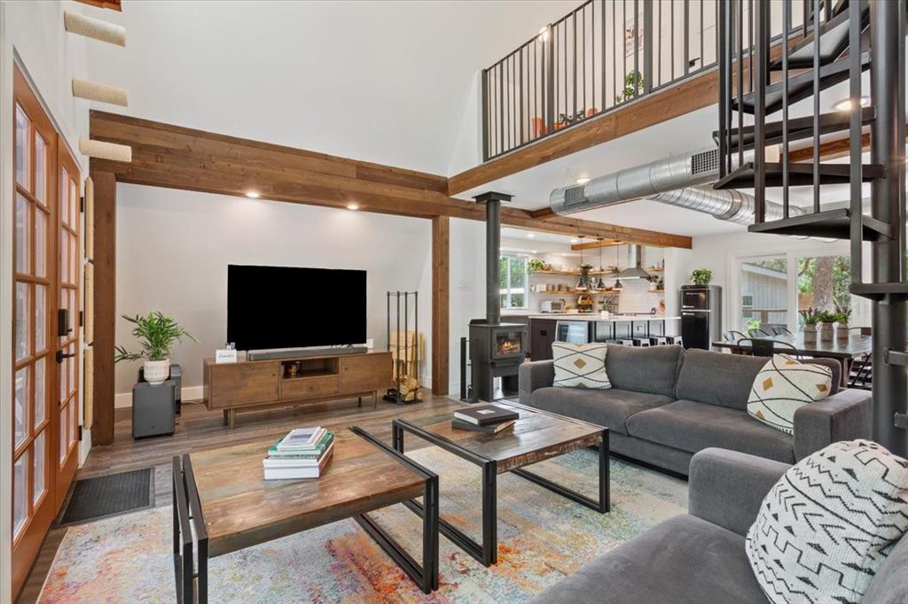 15988 Wortham Bend Road China Spring, TX 76633 - Photo 4 of 40 Vaulted ceiling living space featuring exposed wood beams, a spiral staircase, and a lofted area with metal railings