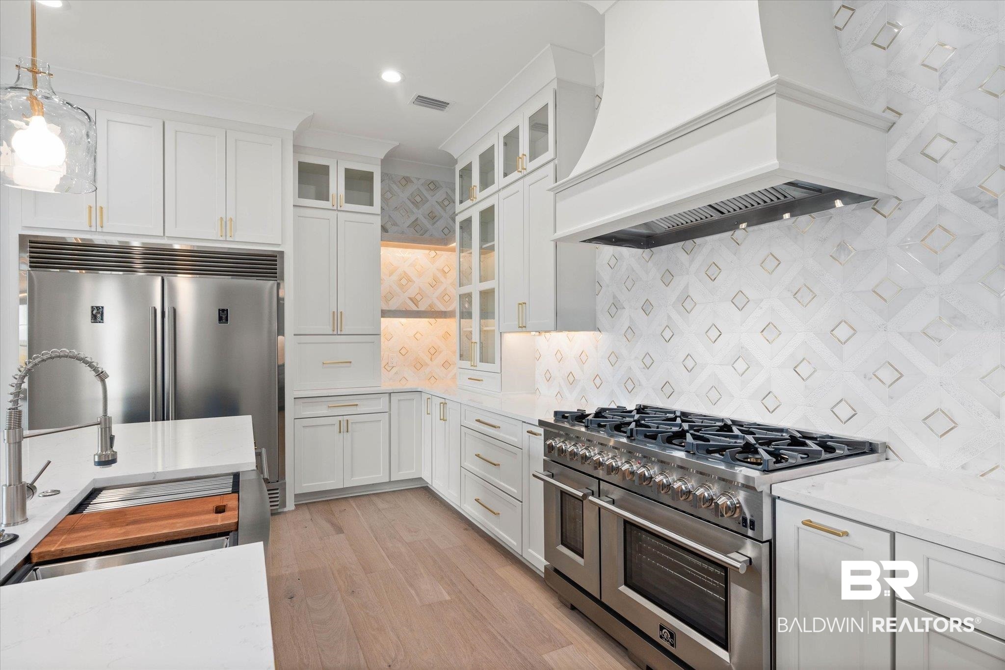 853 Inlet Circle Gulf Shores, AL 36542 - Photo 12 of 55 Kitchen featuring backsplash, visible vents, premium range hood, premium appliances, and white cabinetry