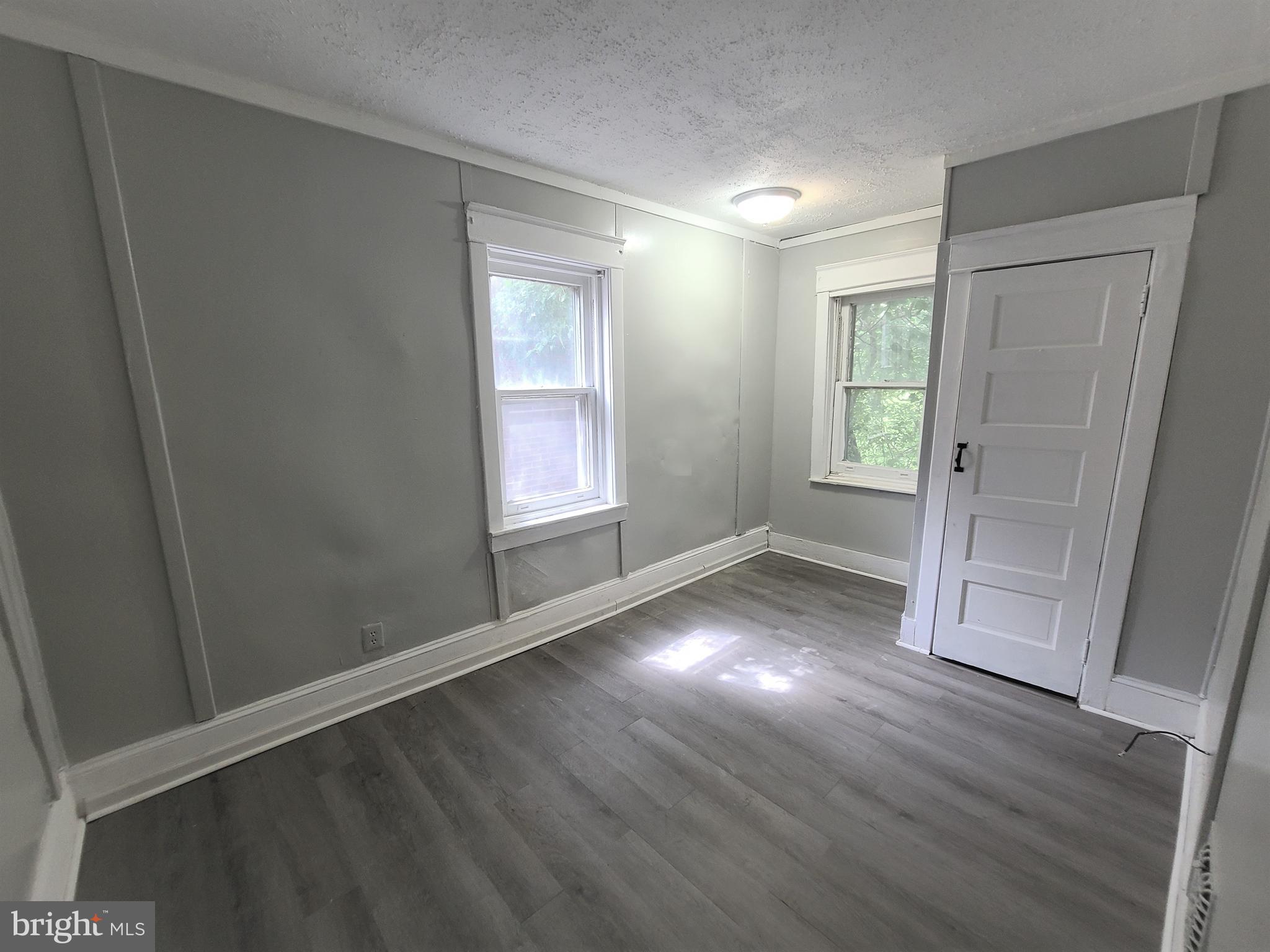 1008 McDowell Avenue Chester, PA 19013 - Photo 13 of 16 an empty room with wooden floor and windows