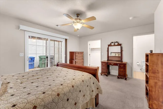 a bedroom with a bed desk and a window