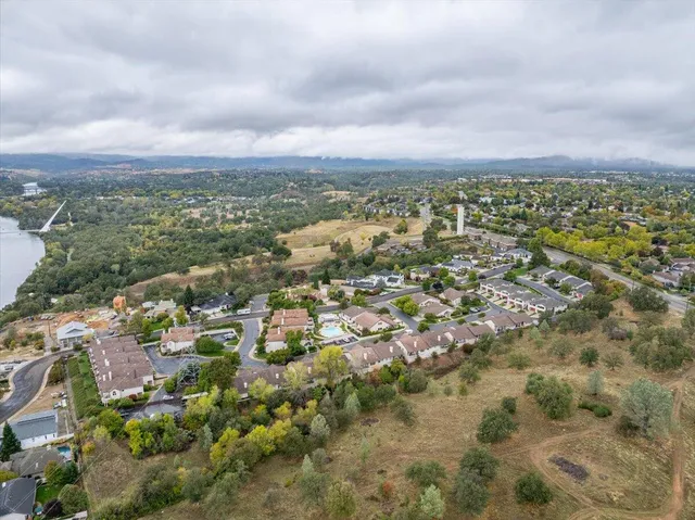 an aerial view of residential houses with outdoor space and trees