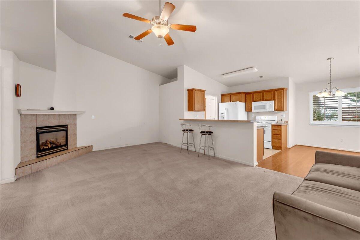 738 Stonebriar Trail Redding, CA 96003 - Photo 6 of 40 a living room with furniture a fireplace and a flat screen tv