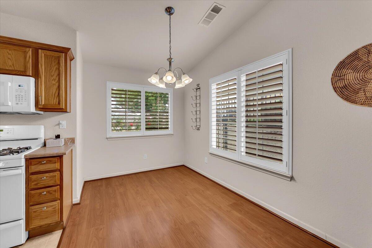 738 Stonebriar Trail Redding, CA 96003 - Photo 10 of 40 a view of an empty room with a window and wooden floor