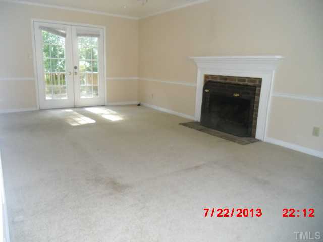 7204 Ewing Place Raleigh, NC 27616 - Photo 3 of 7 an empty room with a fireplace and windows