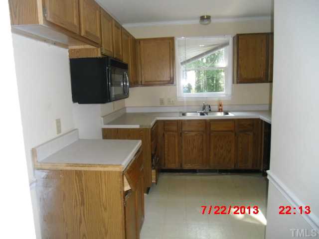 7204 Ewing Place Raleigh, NC 27616 - Photo 5 of 7 a kitchen with a sink a stove and cabinets