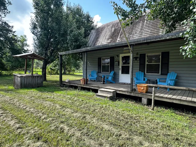 a view of a house with backyard sitting area and garden