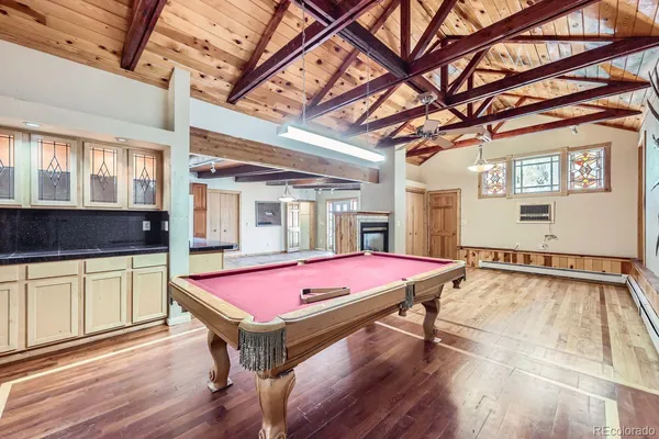 a room with pool table and windows