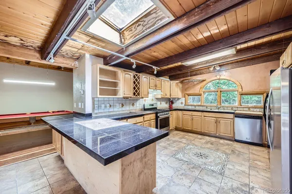 a kitchen with stainless steel appliances granite countertop a sink a stove and a wooden floors