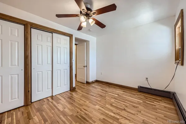 an empty room with ceiling fan and window