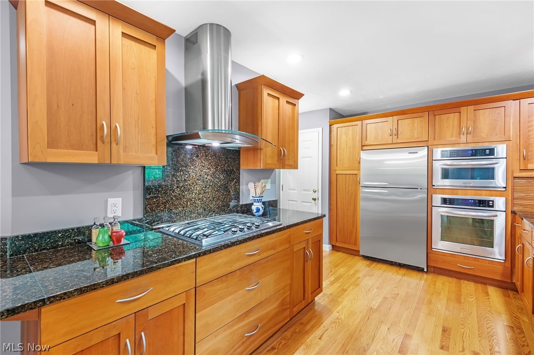 4587 Ranchwood Road Akron, OH 44333 - Photo 4 of 44 Kitchen features a range hood and gas cooktop.