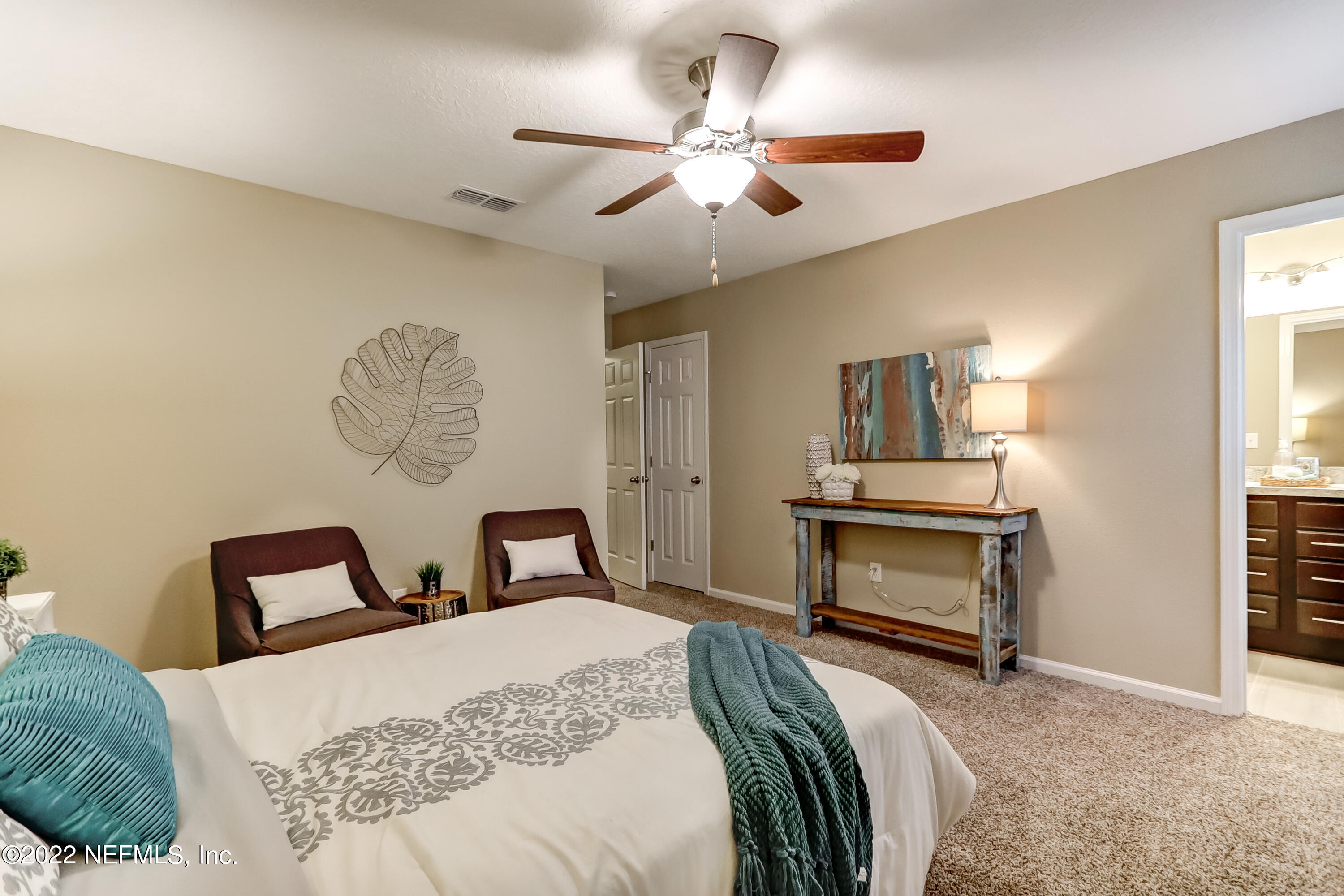 2209 Kistlers Rdg Way Jacksonville, FL 32221 - Photo 21 of 22 a bedroom with a bed and a chandelier