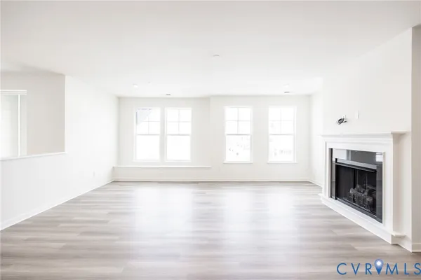 a view of empty room with wooden floor and fireplace