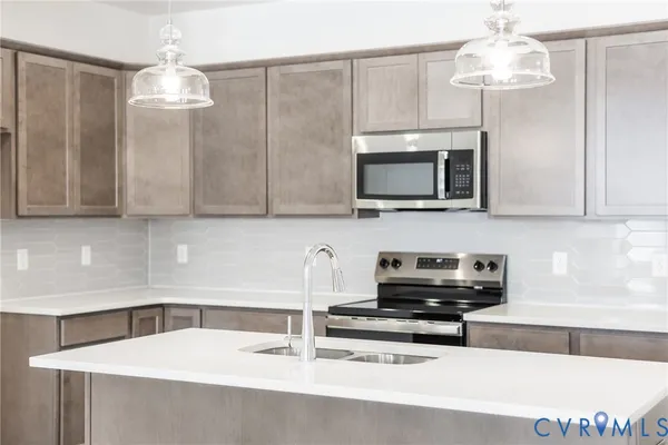 a kitchen with stainless steel appliances a microwave a sink and cabinets