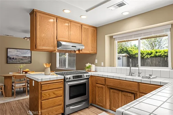 a kitchen with stainless steel appliances granite countertop a sink stove and cabinets