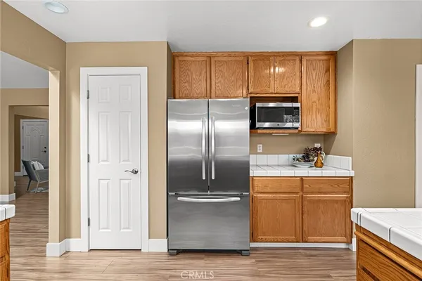 a kitchen with granite countertop a refrigerator and cabinets
