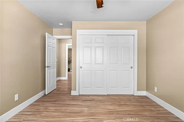 an empty room with wooden floor and closet