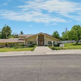 a front view of a house with a yard and potted plants