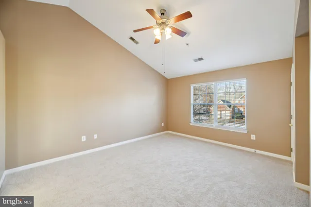 an empty room with a window and a ceiling fan