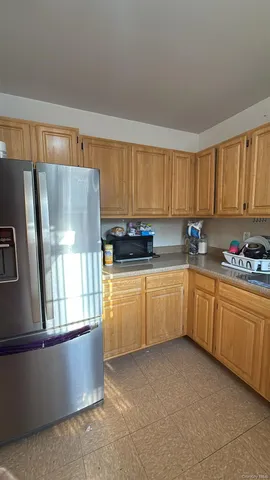 a kitchen with granite countertop a refrigerator sink and cabinets