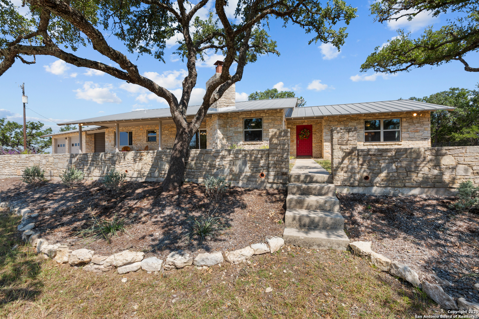 a front view of house with yard and trees around