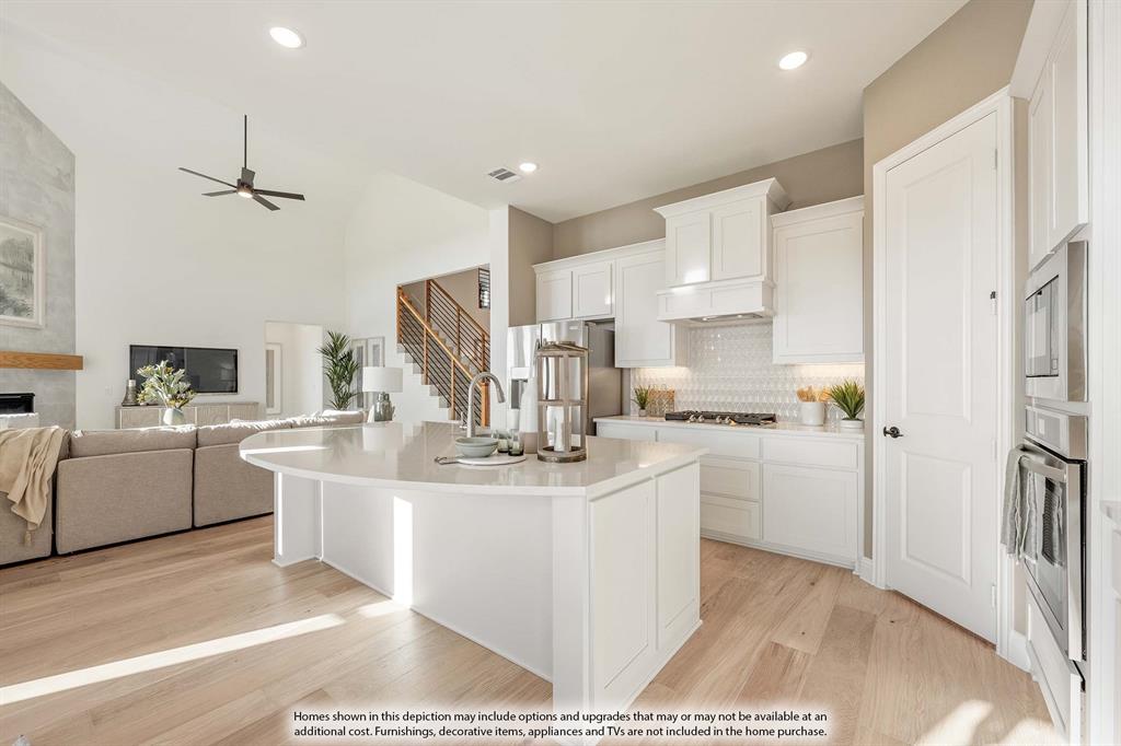 1145 Hitching Post Way Oak Point, TX 75068 - Photo 19 of 36 a kitchen with kitchen island a white counter top space a sink a refrigerator and cabinets