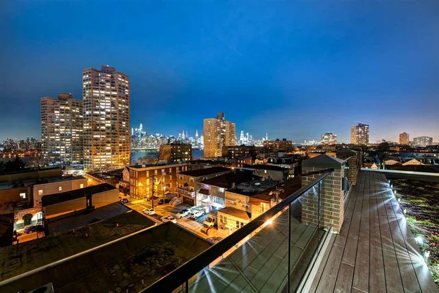 a view of a living room with floor to ceiling windows and a ceiling fan