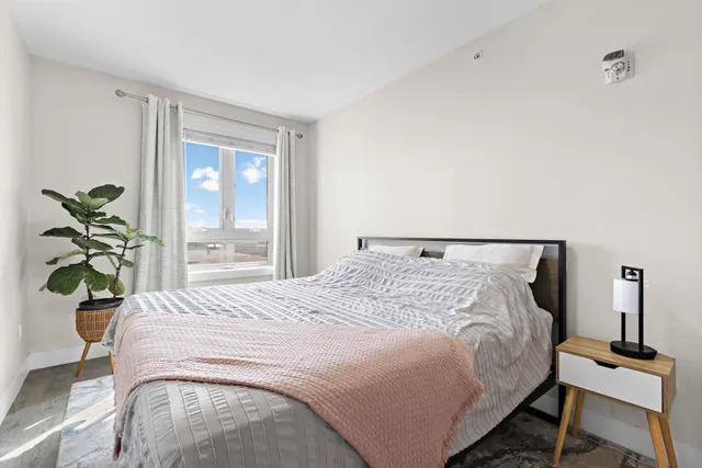 a bedroom with a bed table and a lamp