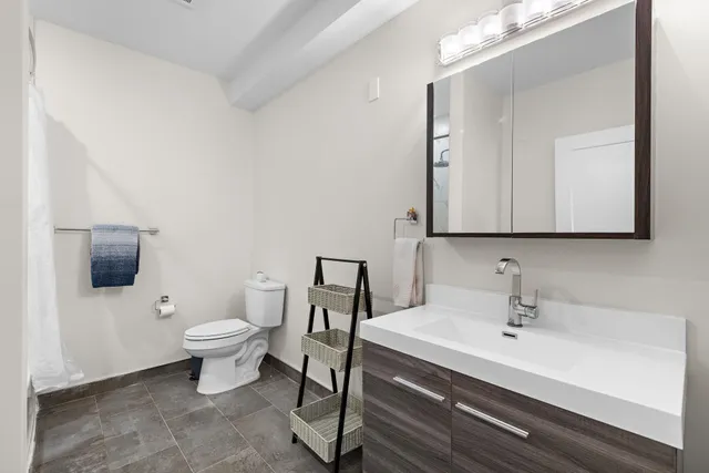 a bathroom with a sink a toilet and mirror