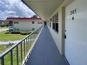 a view of a house with backyard stairs and a porch