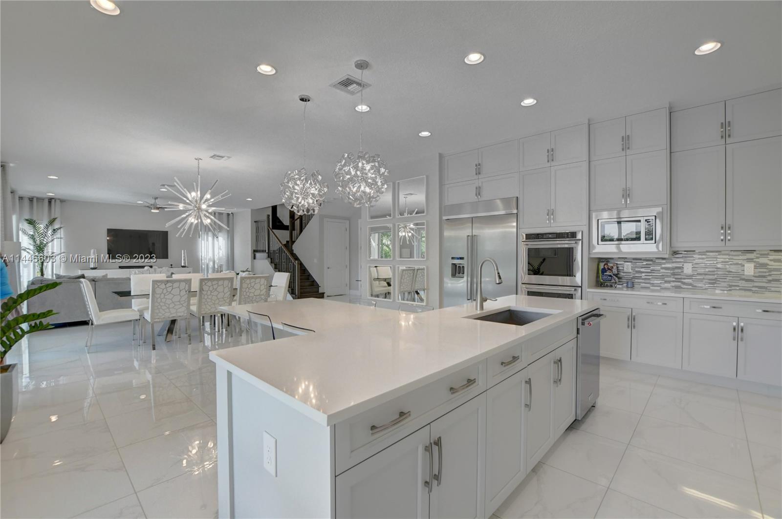 11655 Windy Frst Way Boca Raton, FL 33498 - Photo 16 of 69 a large kitchen with kitchen island a sink table and chairs