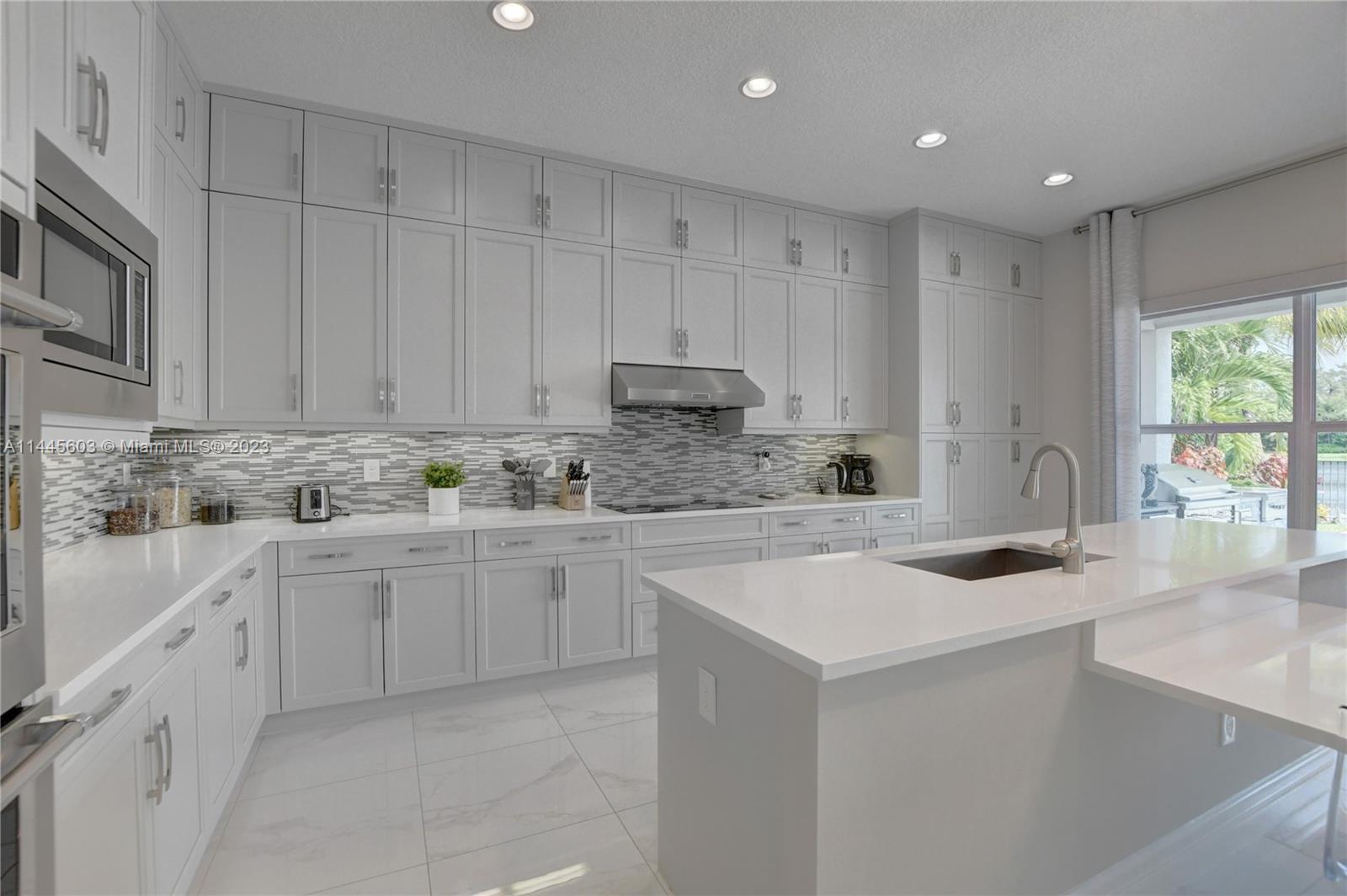 11655 Windy Frst Way Boca Raton, FL 33498 - Photo 17 of 69 a kitchen that has a lot of white cabinets and stainless steel appliances