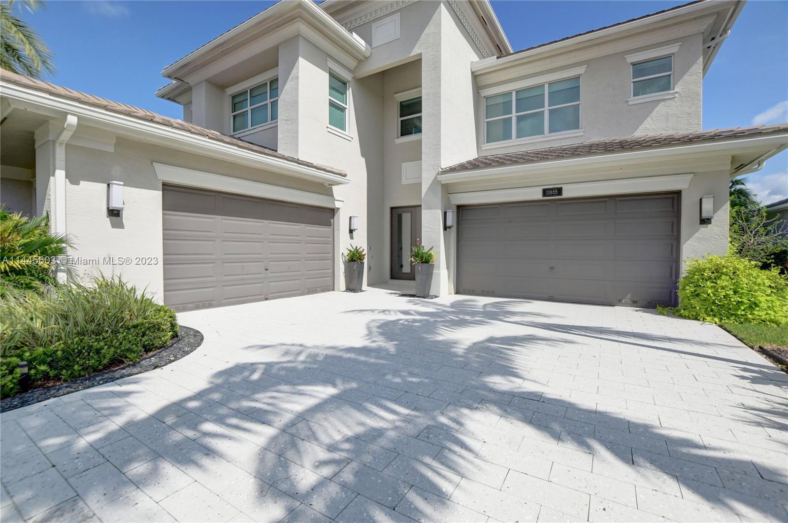 11655 Windy Frst Way Boca Raton, FL 33498 - Photo 2 of 69 a front view of a house with a yard and garage