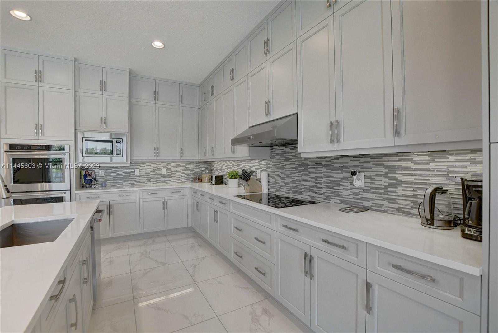 11655 Windy Frst Way Boca Raton, FL 33498 - Photo 21 of 69 a kitchen with white cabinets and white appliances