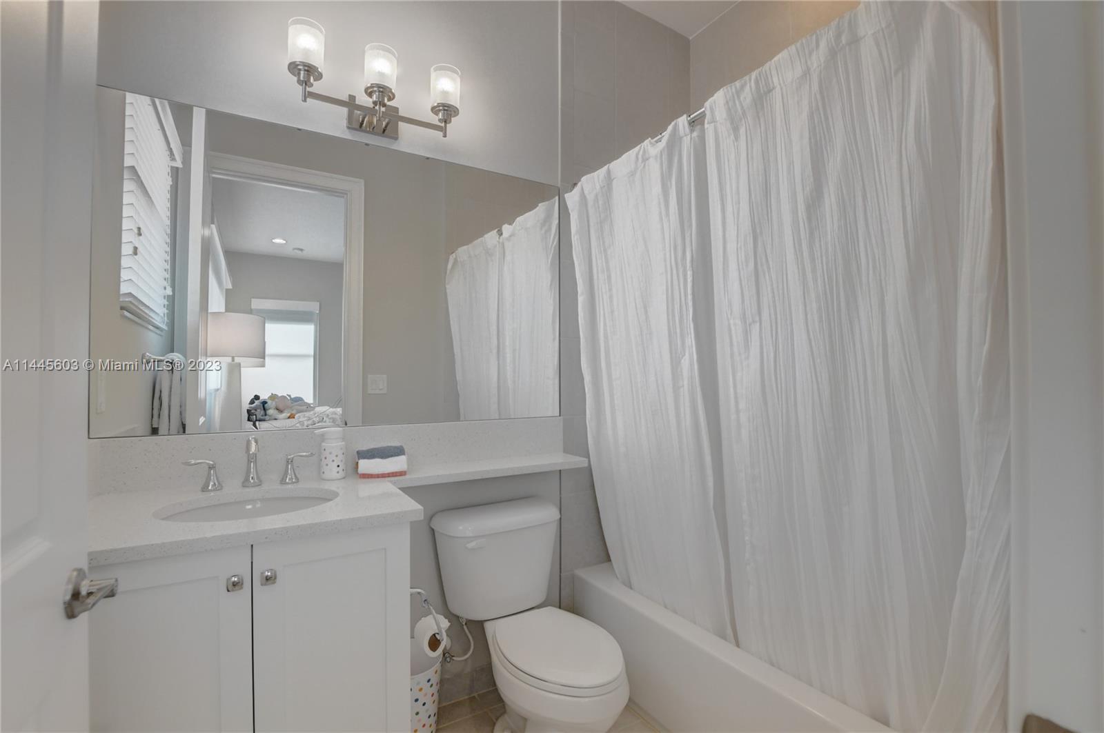 11655 Windy Frst Way Boca Raton, FL 33498 - Photo 44 of 69 a bathroom with a toilet a sink and a mirror