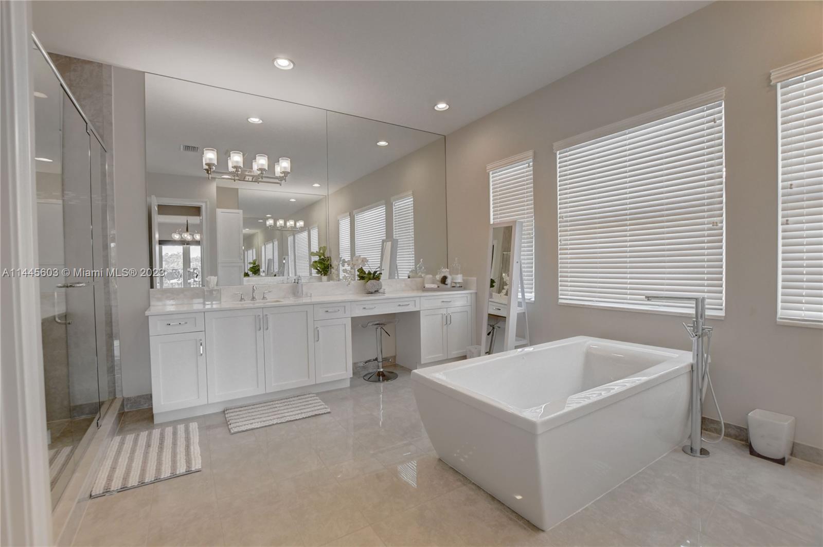 11655 Windy Frst Way Boca Raton, FL 33498 - Photo 45 of 69 a large white bathroom with a large tub shower vanity and a sink