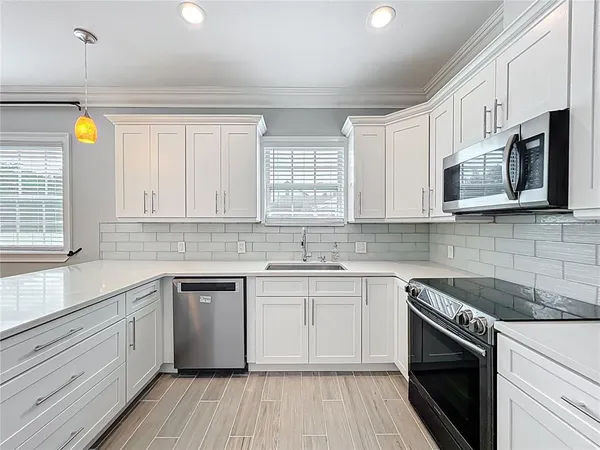 a kitchen with stainless steel appliances a refrigerator sink and microwave