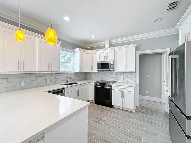 a kitchen with stainless steel appliances granite countertop a sink and a stove