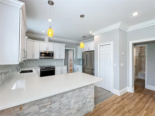 a kitchen with stainless steel appliances a refrigerator sink and microwave