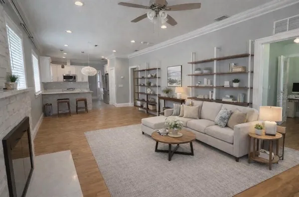 a living room with furniture kitchen view and a chandelier