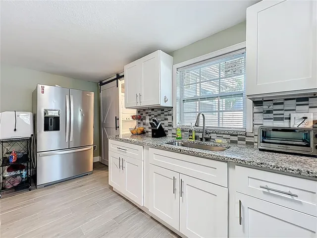 a kitchen with appliances cabinets and a potted plant