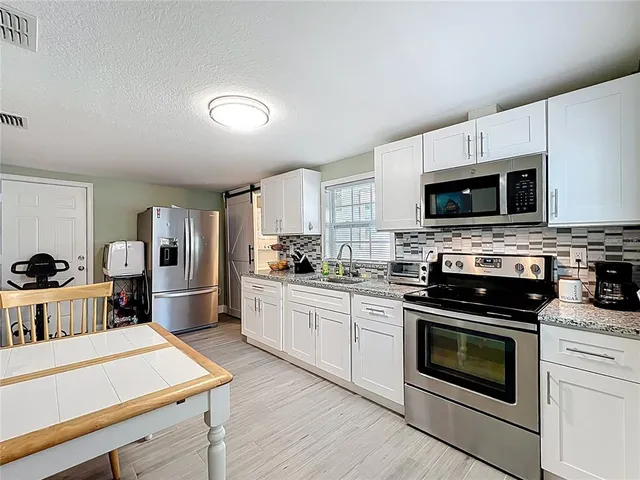 a kitchen with a stove a sink and a microwave