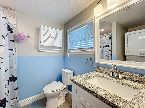 a view of washer and dryer with bathroom in the background