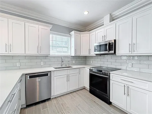 a kitchen with stainless steel appliances a refrigerator and microwave